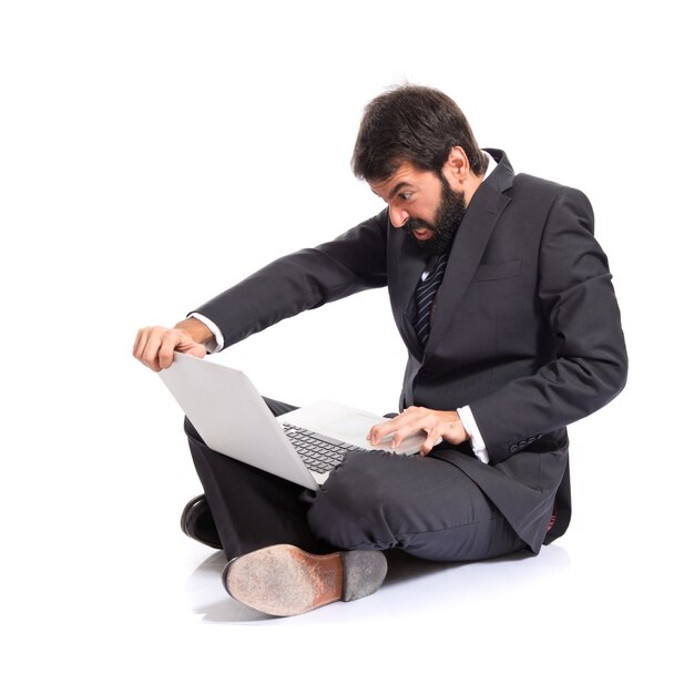Enojado hombre de negocios con ordenador portátil sobre fondo blanco
