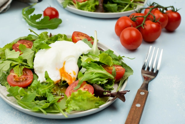 Ensalada de alto ángulo con huevo frito y tomates cherry