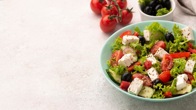 Ensalada de alto ángulo con queso feta, tomates y aceitunas con espacio de copia