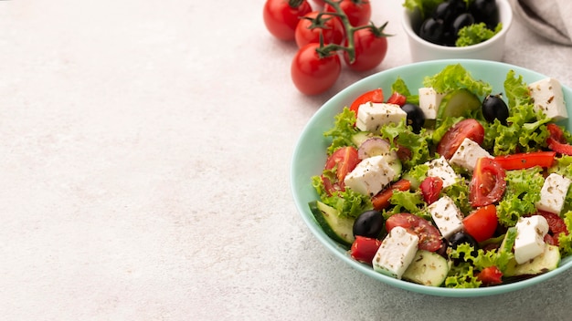 Ensalada de alto ángulo con queso feta, tomates y aceitunas con espacio de copia