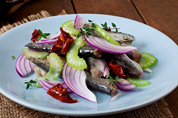 Ensalada de arenque con tomates secados al sol, apio y cebolla roja