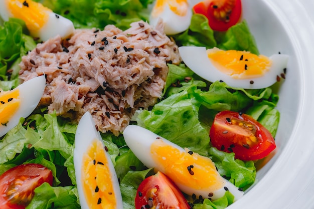 Foto gratuita ensalada de atún huevo tomate lechuga sésamo vista lateral