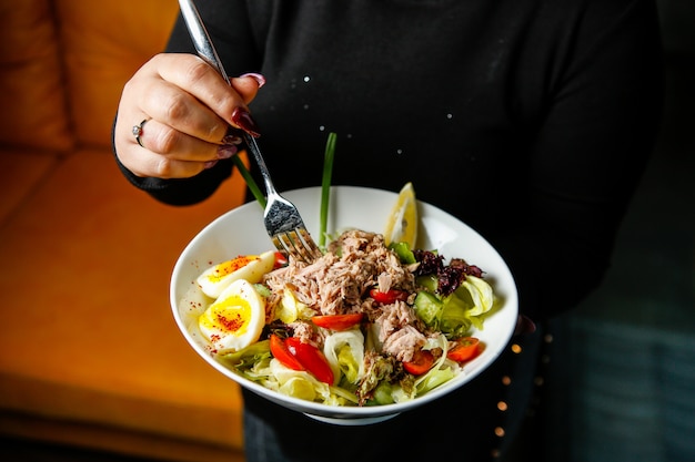 Ensalada de atún con rodajas de huevo y pimiento rojo vista lateral