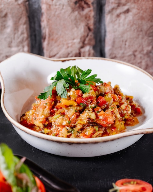 Ensalada azerbaiyana de mangal con perejil hojas en plato blanco.