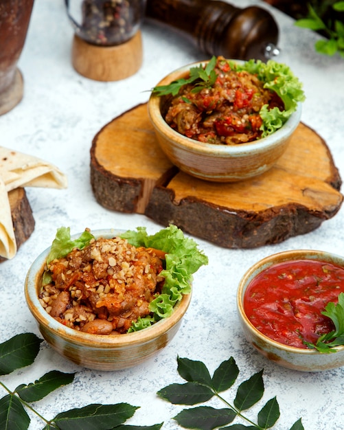 Ensalada de barbacoa en cazuela de barro sobre un tocón