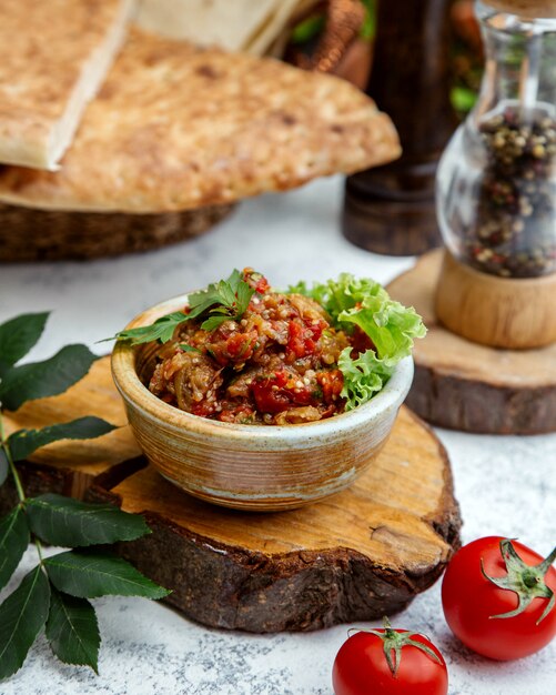 Ensalada de barbacoa en cerámica sobre un cáñamo de madera