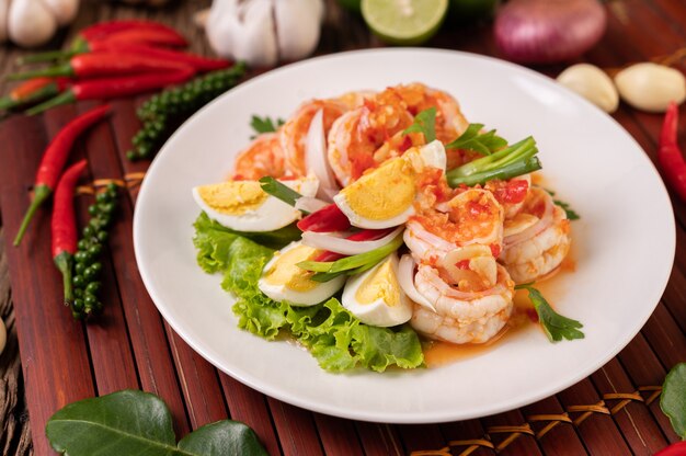 Ensalada de camarones con lechuga hervida y cebolletas picadas en un plato blanco