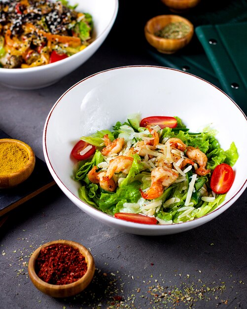 Ensalada de camarones con lechuga tomates y queso rallado