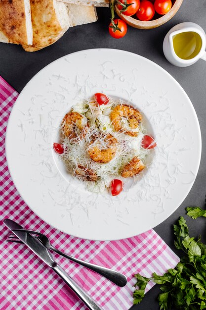 Ensalada con camarones, lechuga, tomates y queso rallado