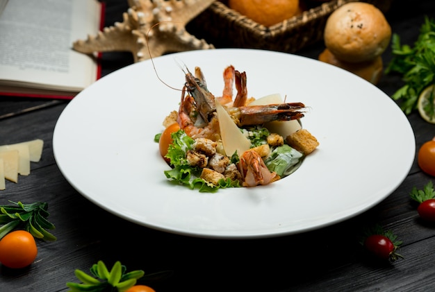 Ensalada de cangrejo de mariscos con parmesano fresco, galletas saladas, vegetación dentro de un plato blanco