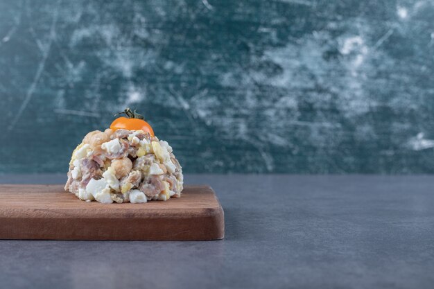 Ensalada de carne deliciosa sobre tabla de madera.