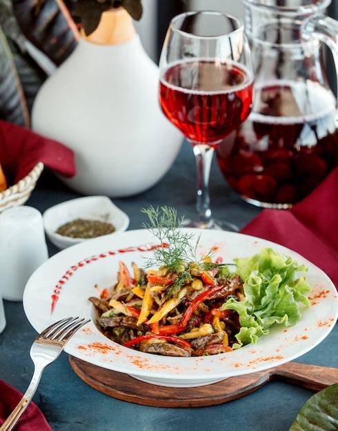 Ensalada de carne frita con coloridos pimientos pepinos encurtidos maíz y hierbas