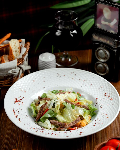 Ensalada de carne con lechuga sobre la mesa