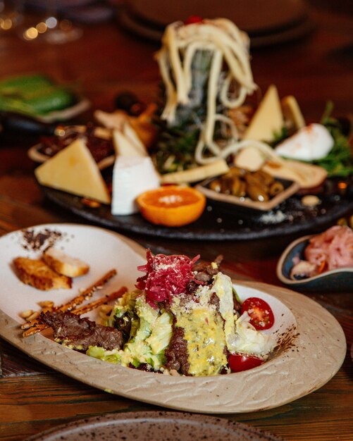 Ensalada de carne con lechuga, tomate cherry, queso rallado y salsa