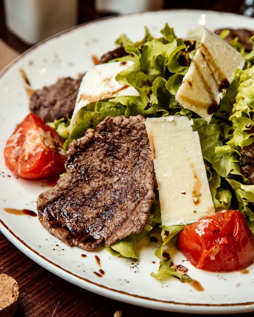 Ensalada de carne lechuga tomate queso vista lateral