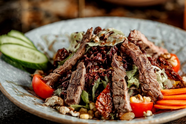 Ensalada de carne con lechuga, tomates, pepinos y nueces