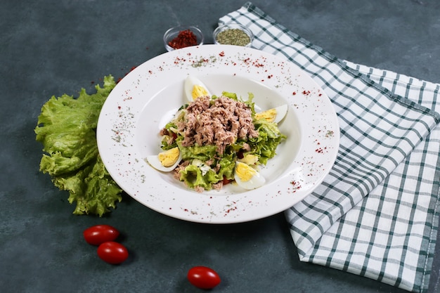 Ensalada de carne y verduras con huevos duros y tomates.