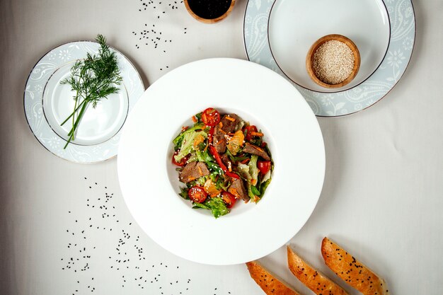 Ensalada de carne con verduras sobre la mesa