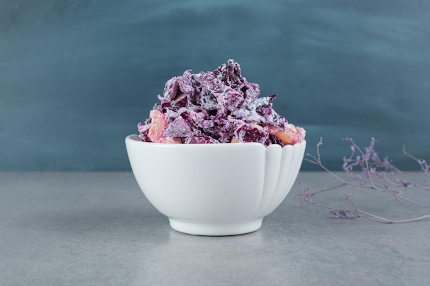 Ensalada de cebolla morada y repollo picada en tazas de cerámica.