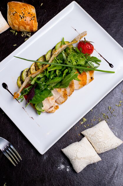 Ensalada César galletas de pollo lechuga tomate parmesano anchoas vista superior