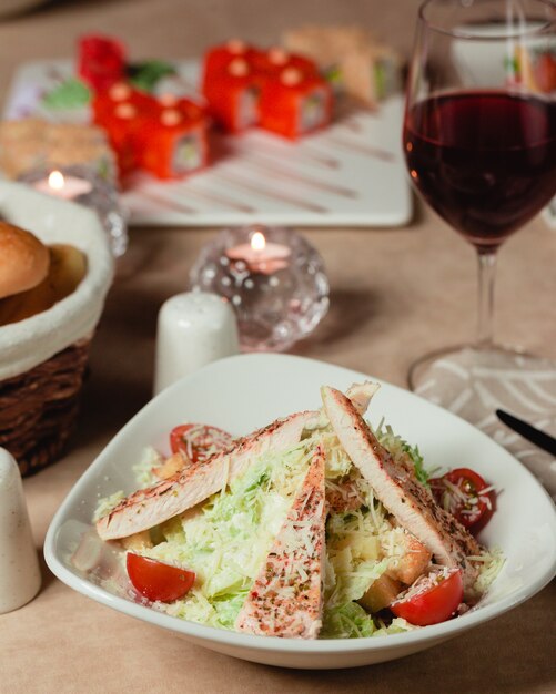 Ensalada César griega con carne blanca, lechuga y tomates cherry.