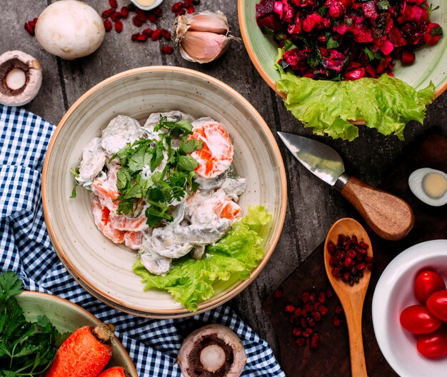 Ensalada de champiñones con zanahorias y mayonesa vista superior sobre la mesa