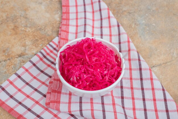 Ensalada de chucrut rojo en un tazón blanco con mantel