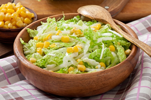 Ensalada de col china con maíz dulce en un tazón de madera