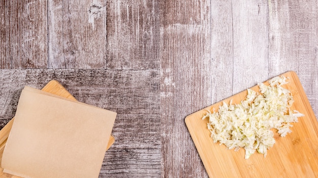 Ensalada de col vegana sobre tabla de madera junto a una placa vacía