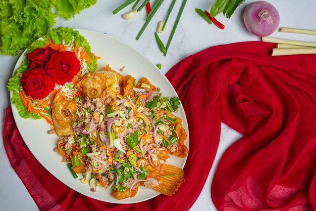 Ensalada crujiente de pescado Tubtim, hierba de comida tailandesa.