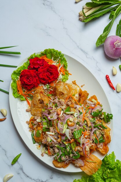 Ensalada crujiente de pescado Tubtim, hierba de comida tailandesa.