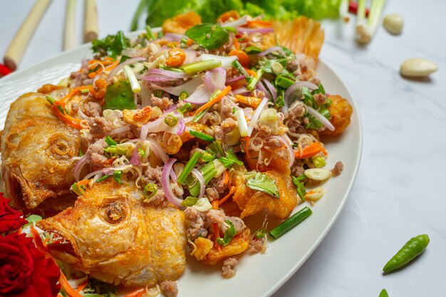 Ensalada crujiente de pescado Tubtim, hierba de comida tailandesa.