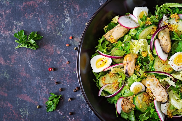 Ensalada dietética con mejillones, huevos de codorniz, pepinos, rábanos y lechugas. Comida sana. Ensalada de mariscos. Vista superior. Endecha plana.