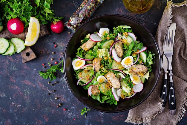 Ensalada dietética con mejillones, huevos de codorniz, pepinos, rábanos y lechugas. Comida sana. Ensalada de mariscos. Vista superior. Endecha plana.