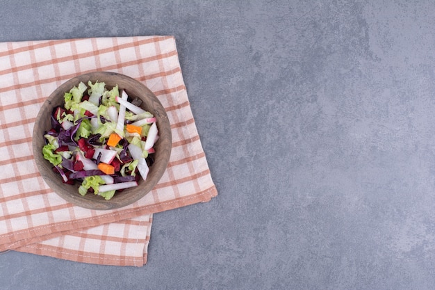 Foto gratuita ensalada dietética en una placa de madera con ingredientes mixtos