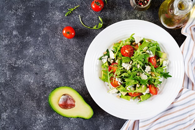 Ensalada dietética con tomate, queso azul, aguacate, rúcula y piñones.