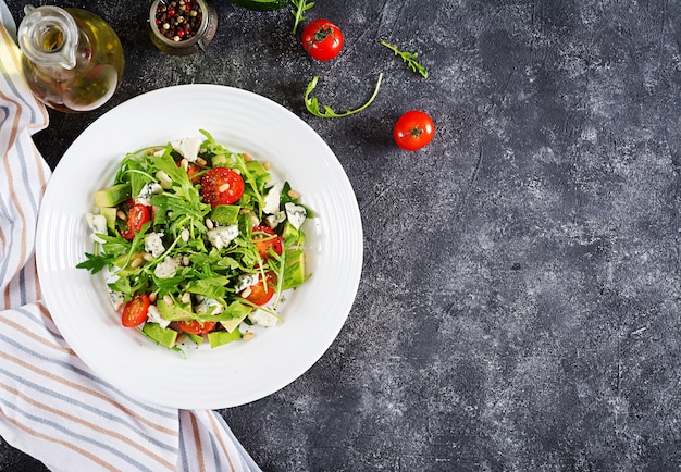 Ensalada dietética con tomate, queso azul, aguacate, rúcula y piñones.