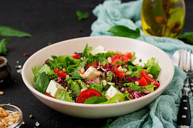 Ensalada dietética con tomate, queso feta, lechuga, espinacas y piñones.