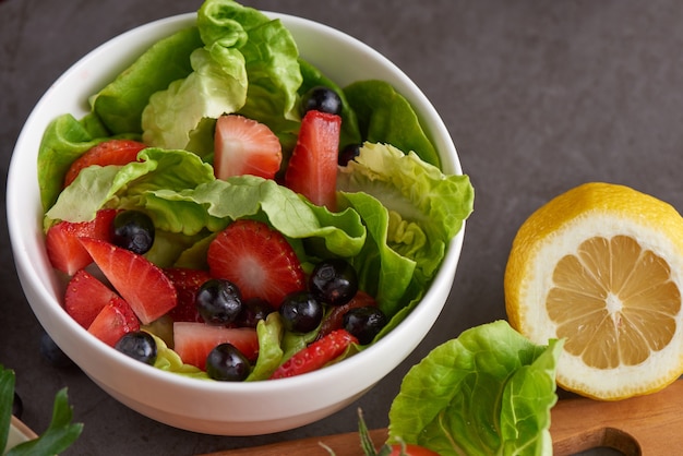 Ensalada de fresas saludables con butterhead, moras en un plato blanco.