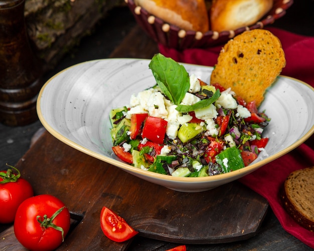 Foto gratuita ensalada fresca con queso y hierbas y una rebanada de pan crujiente