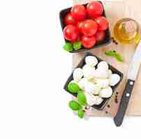 Foto gratuita ensalada fresca con tomates cherry, albahaca, mozzarella y aceitunas negras.