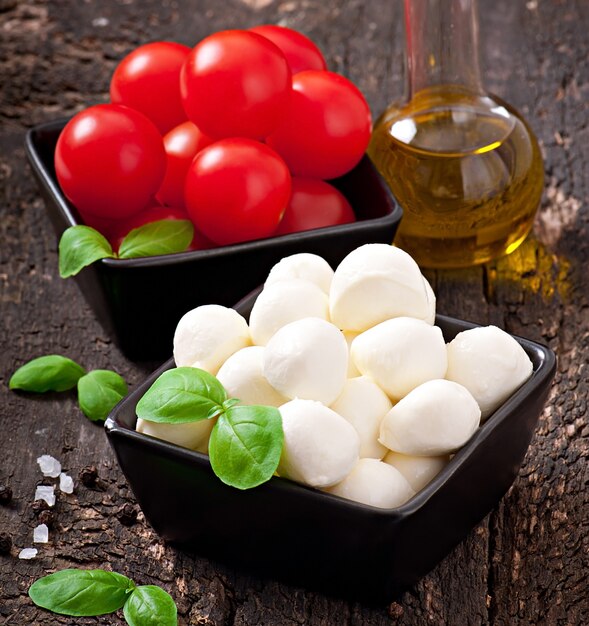 Ensalada fresca con tomates cherry, albahaca, mozzarella y aceitunas negras.