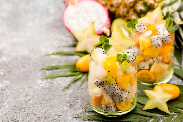 Foto gratuita ensalada de frutas en espacio de copia de vidrio