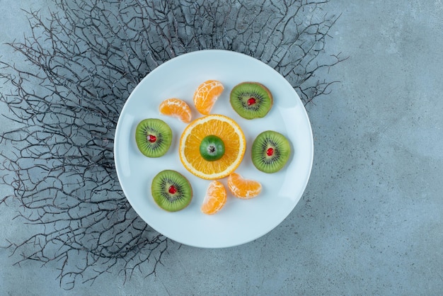 Ensalada de frutas con kiwies picados y en rodajas, mandarina y naranjas.