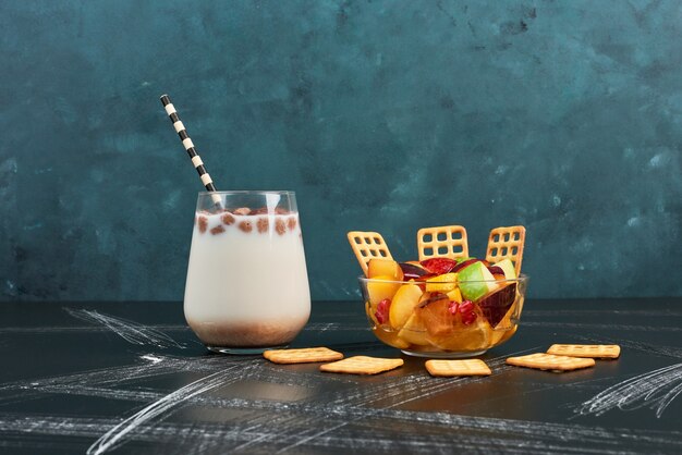 Ensalada de frutas con leche y galletas saladas.