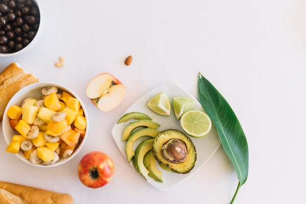 Ensalada de frutas y pan sobre fondo blanco