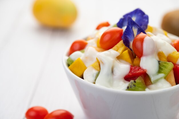 Ensalada de frutas en un recipiente en el piso de madera.