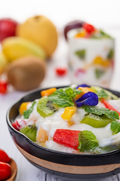 Ensalada de frutas en un recipiente en el piso de madera.