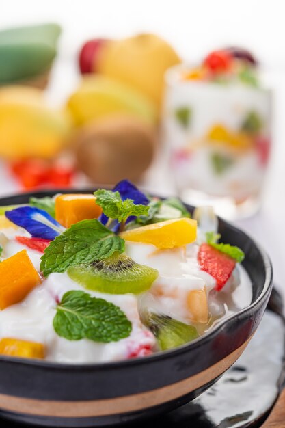 Ensalada de frutas en un recipiente en el piso de madera.