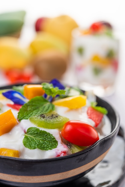 Ensalada de frutas en un recipiente en el piso de madera.